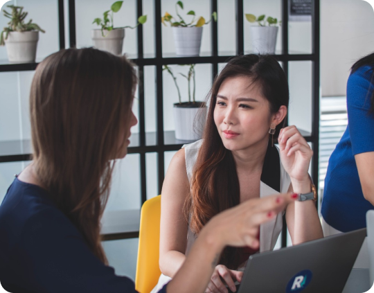 Two Women Having A Conversastion In Front Of A Laptop